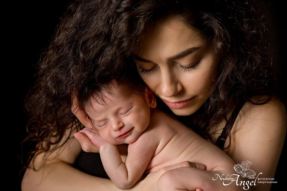 Новорожденная девочка на руках у красивой мамы 