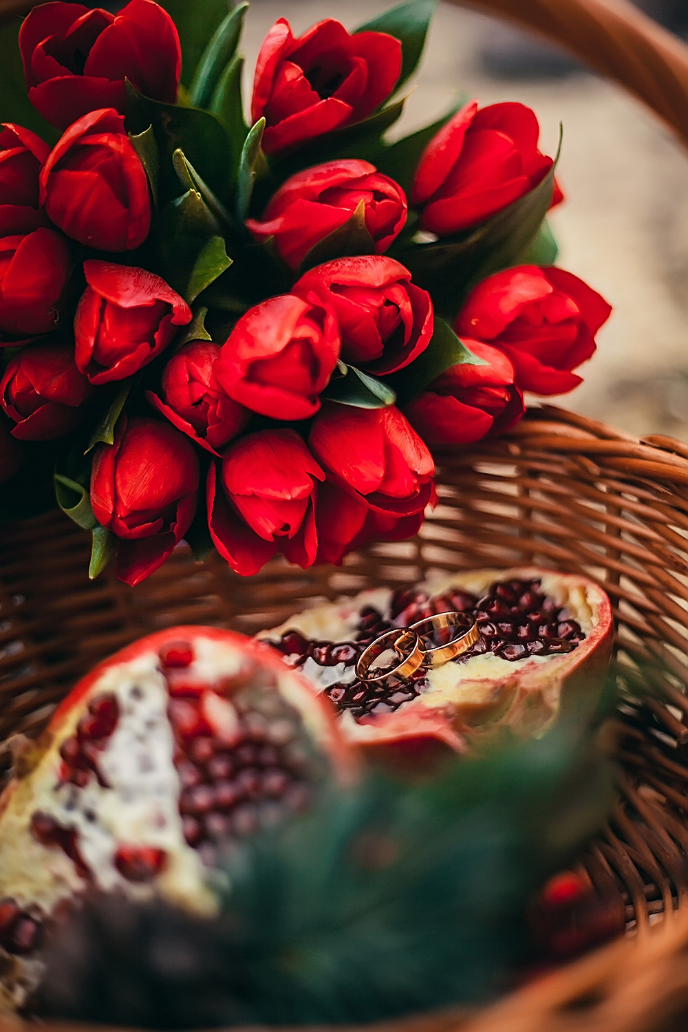 Свадебный букет из красных тюльпанов  в плетеной корзине с гранатами