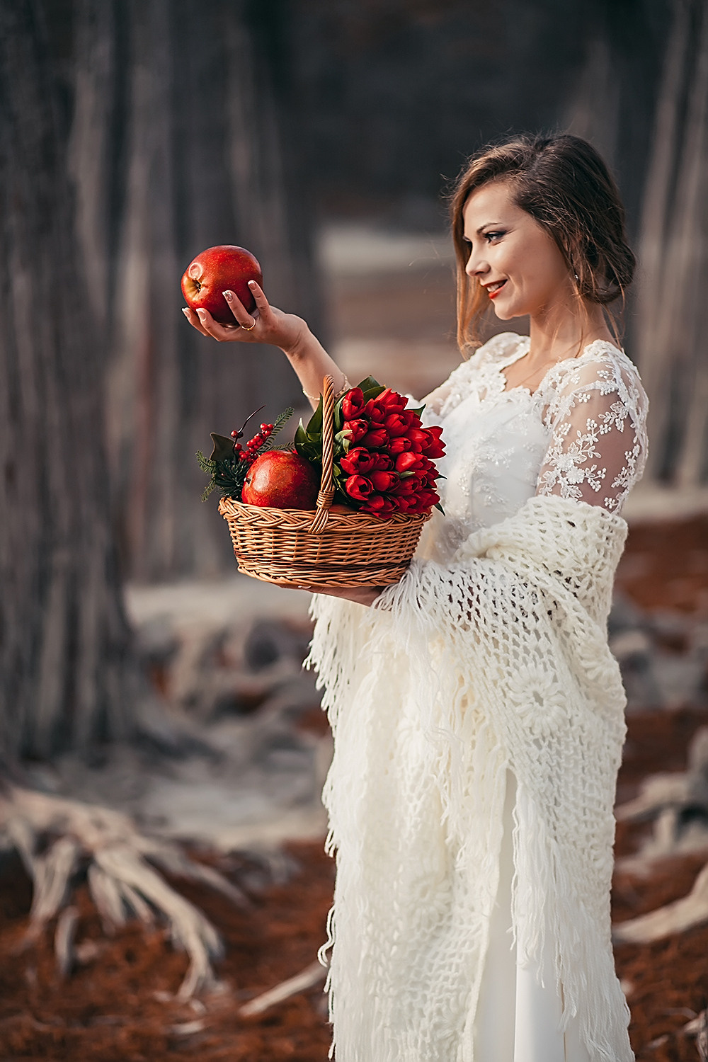 Невеста стоит с корзиной фруктов в руках в осеннем лесу