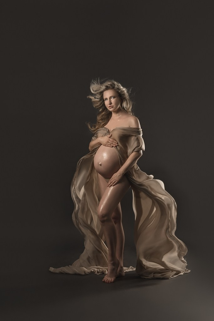 фотосессия беременной в фотостудии на темном фоне в красивом разлетающемся платье, фотография беременности, фотосессия беременных, портрет беременной