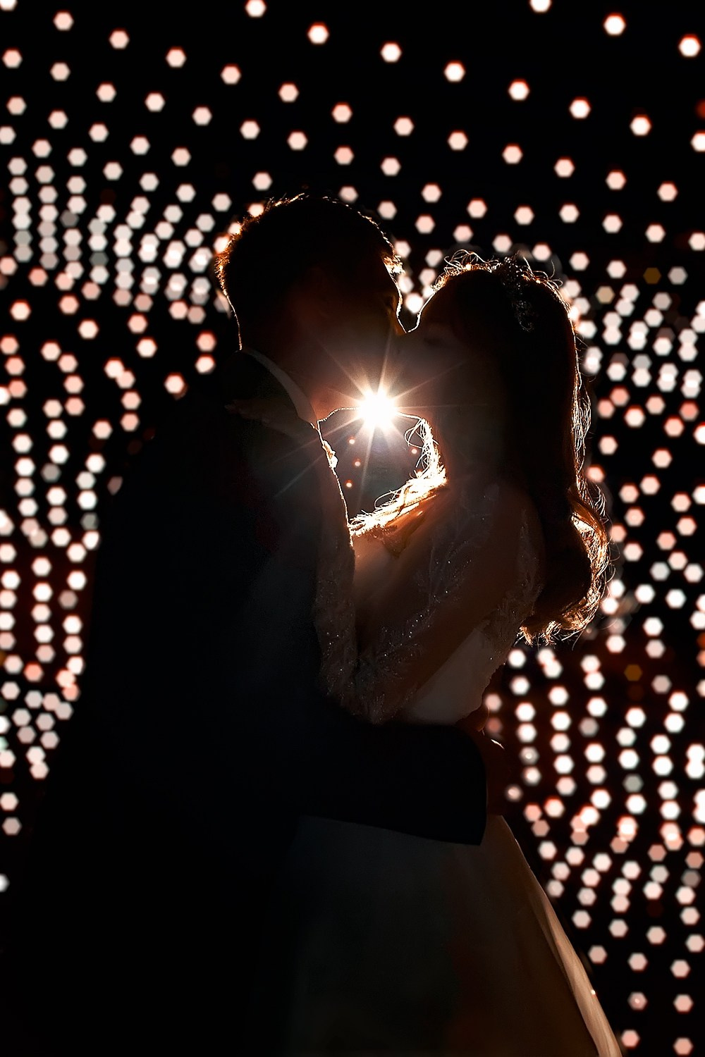 Невеста и жених целуются на фоне праздничной иллюминации - фотограф Янкаускене Наталья