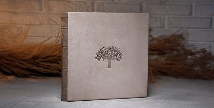 Премиальная фотокнига в обложке из натуральной кожи серо-коричневого цвета с тиснением дерева.