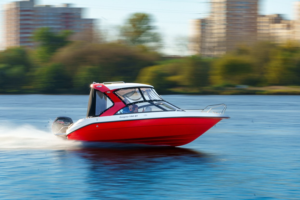 Катер Enigma на скорости, брызги и отражение корпуса