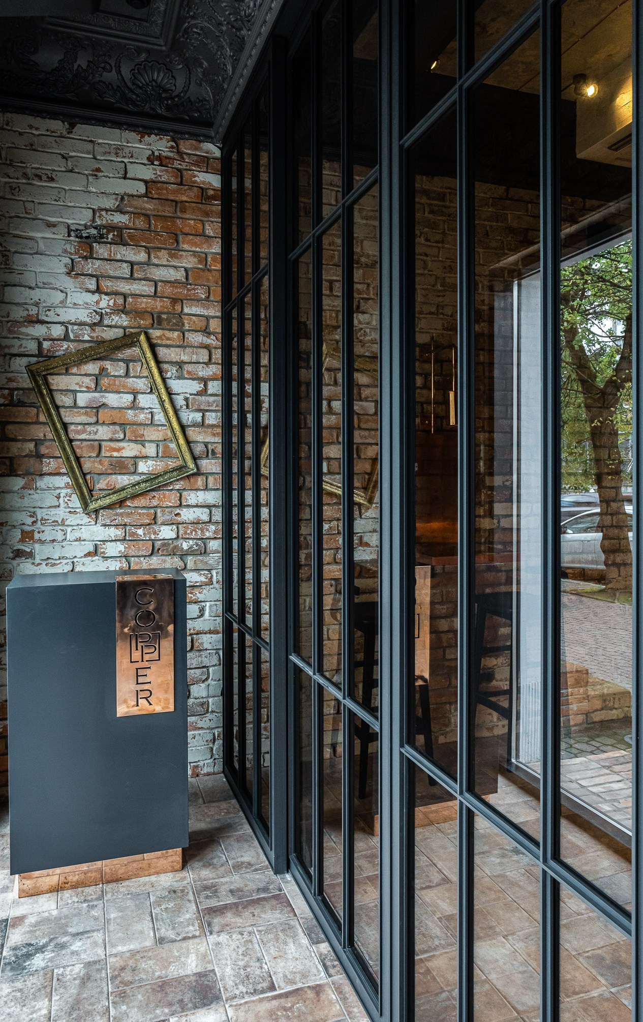 Ресепшен с медной отделкой и золотой рамкой в калининградском ресторане Copper.