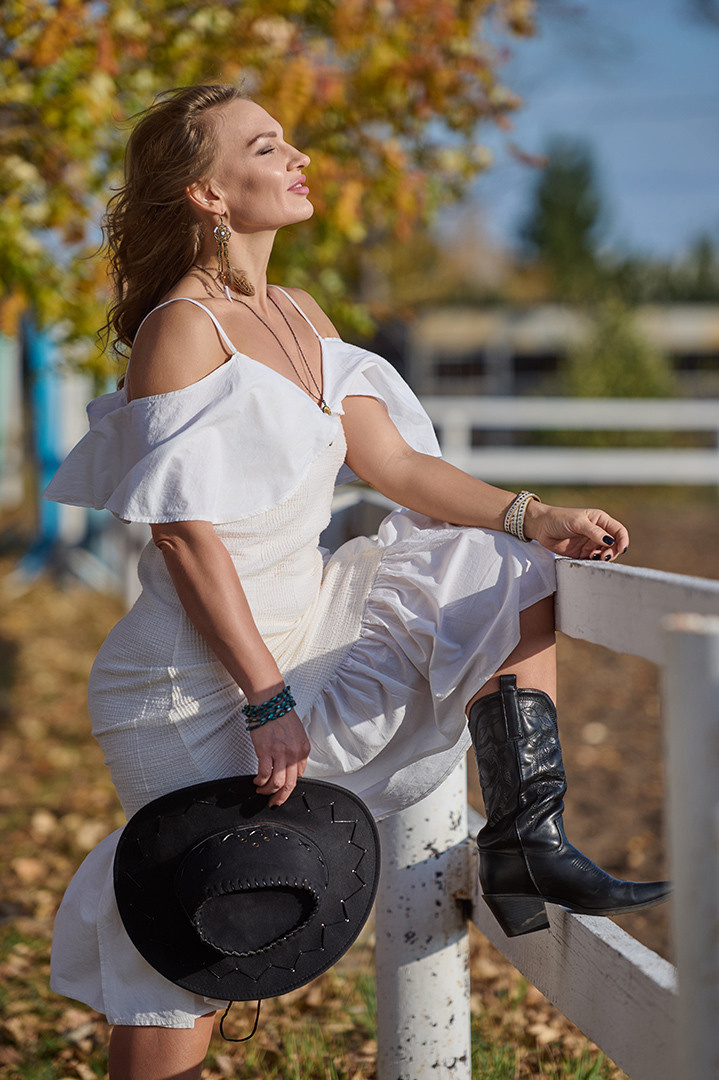 Молодая женщина смотрит в даль осенью в парке.