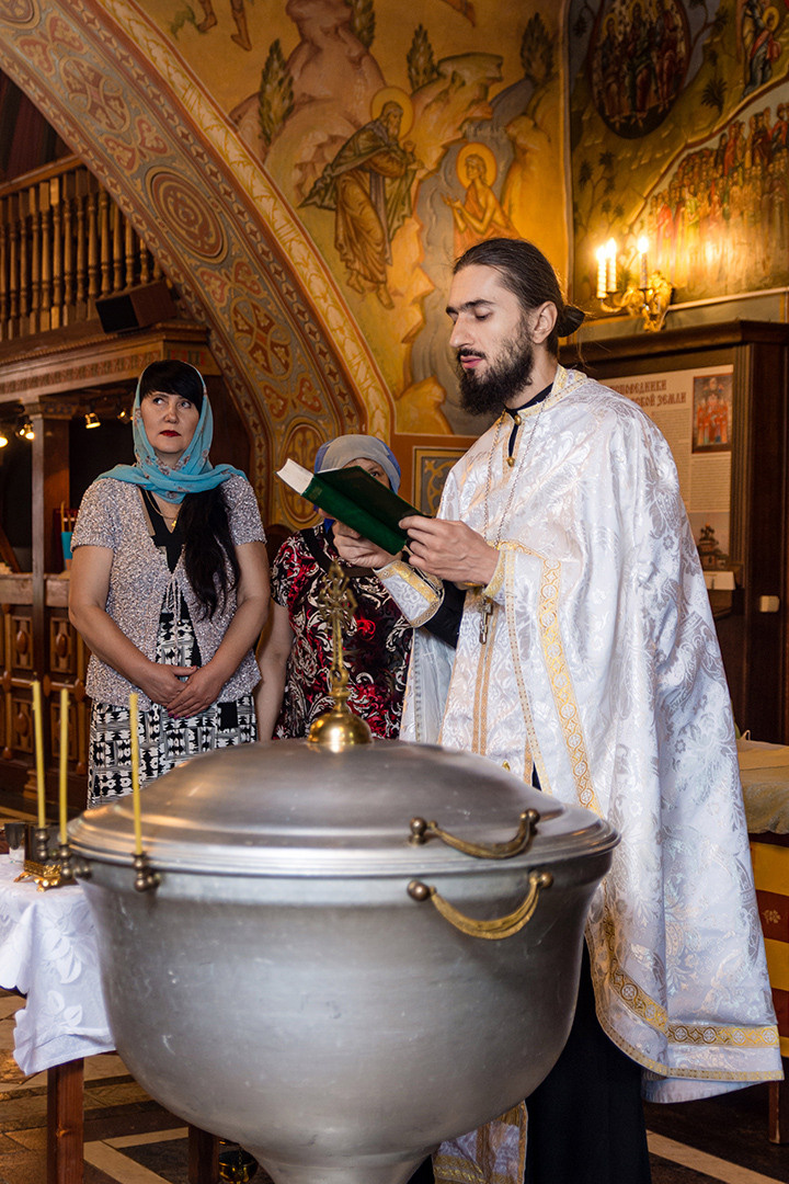 священнослужитель РПЦ в храме читает молитвы