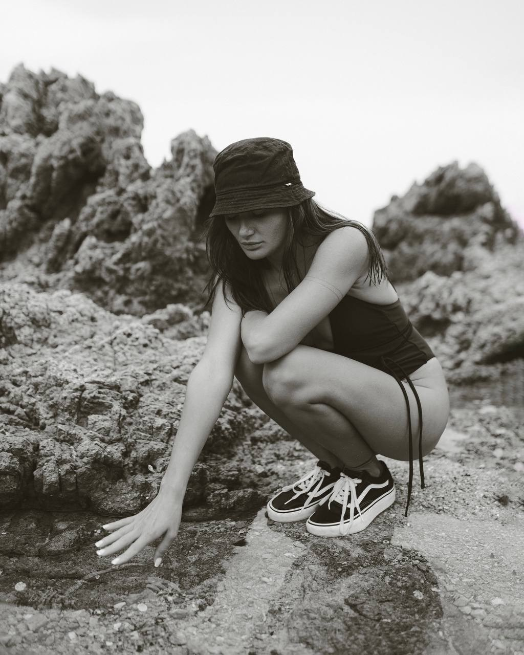 Девушка в панаме у камней в чёрно-белом кадре
