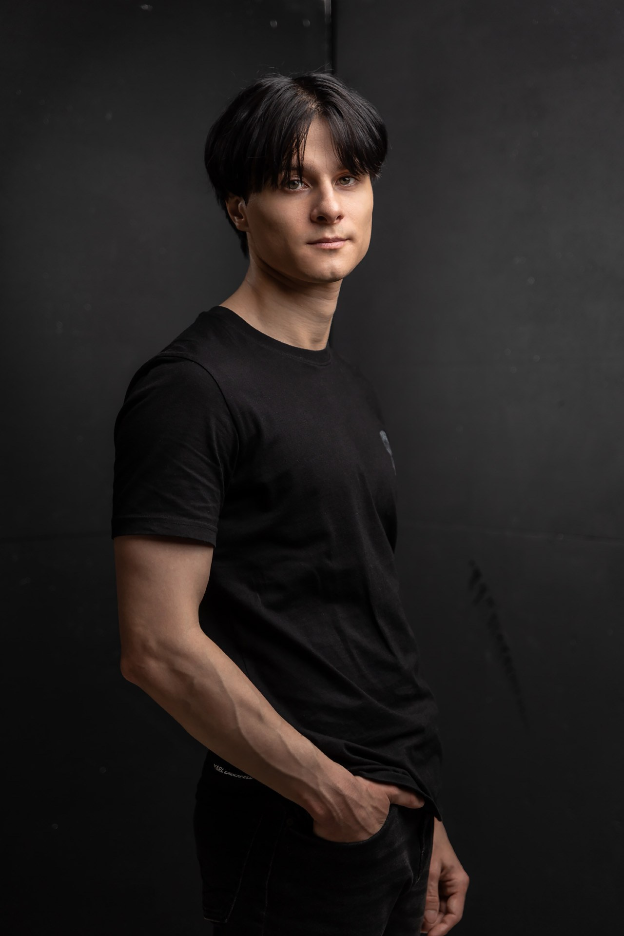 Юноша в черной футболке на черном фоне