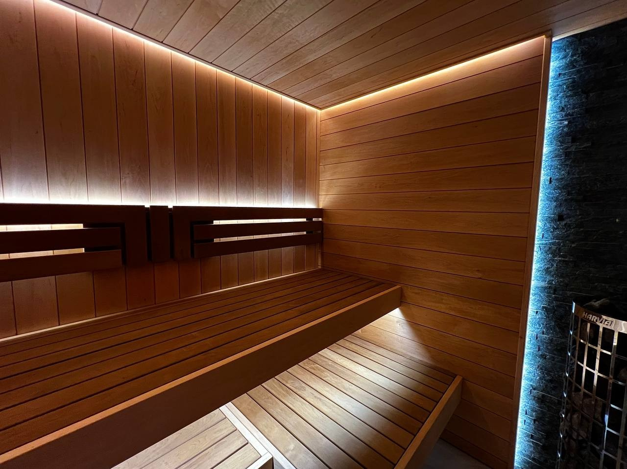 Уютная сауна в КП Новый Мир. В центре внимания- Harvia Cilindro, а закарнизное освещение плавно перетекает в подсветку противопожарного угла. SaunaTopMasters