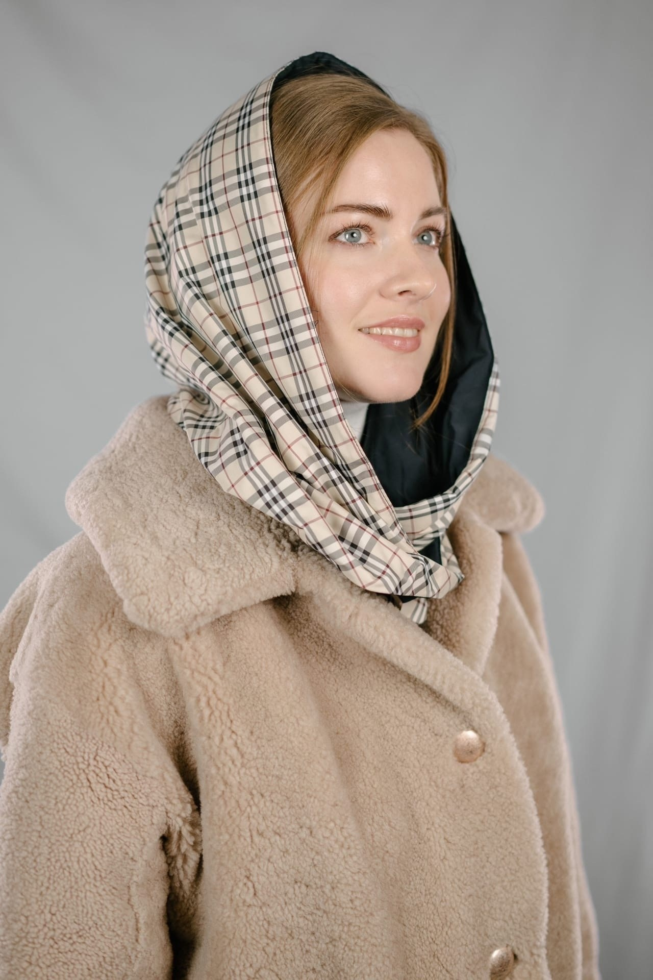 Девушка в бежевой шубе и шарфе на голове