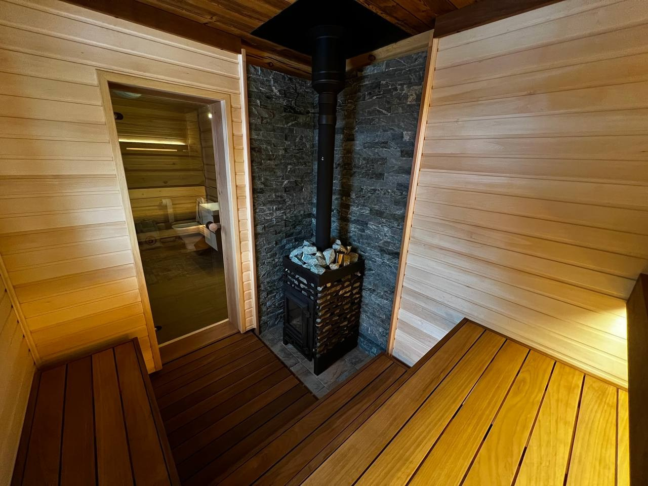 Парная в Коробицино выполнена из необычного сочетания светлой липы, термоабаши и брашированной доски Шале на потолке. SaunaTopMasters