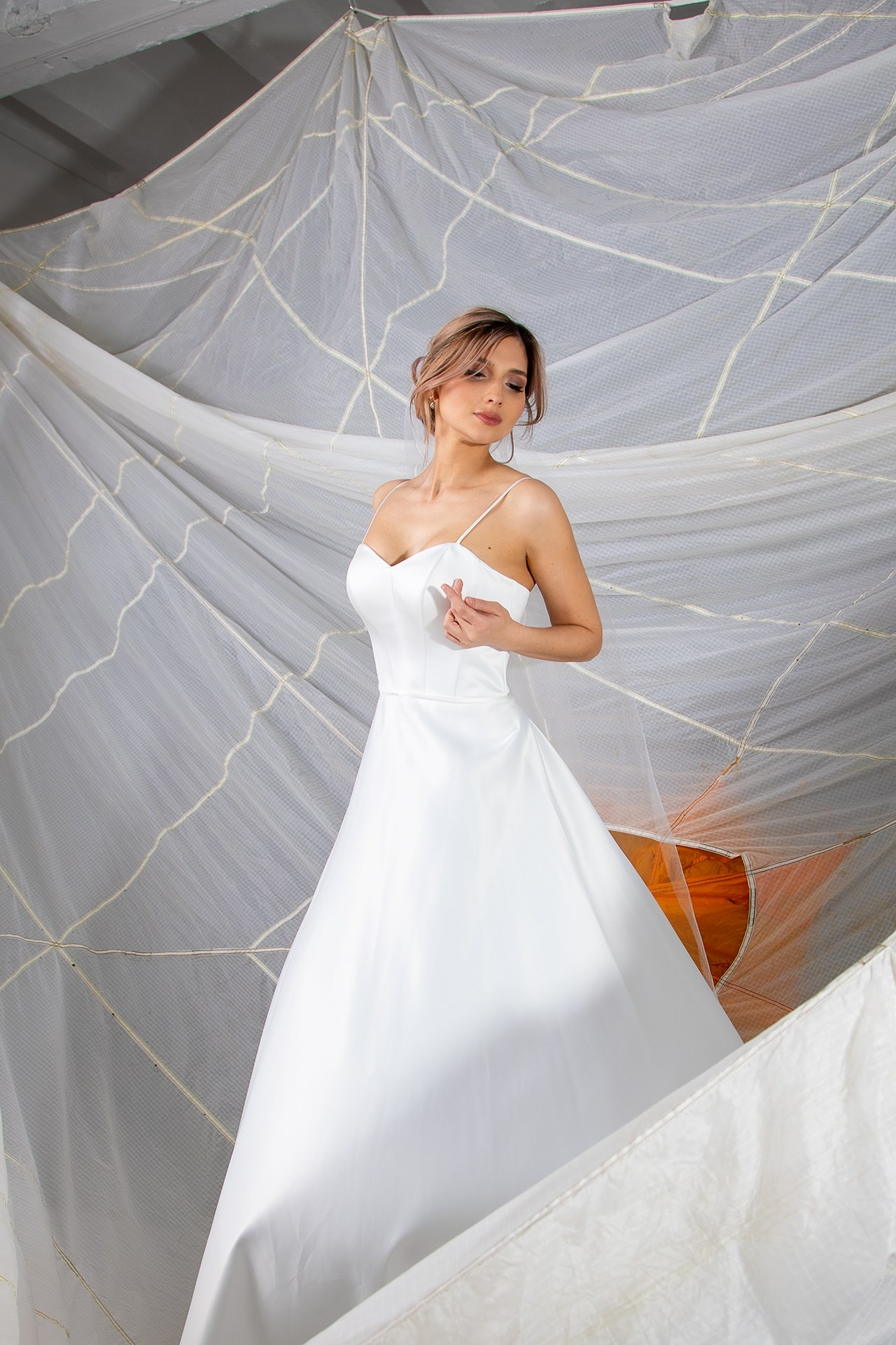 art свадебная фотография девушка в белом платье стоит в парашу тебя в студии невеста свадьба Кемерово Кузбасс