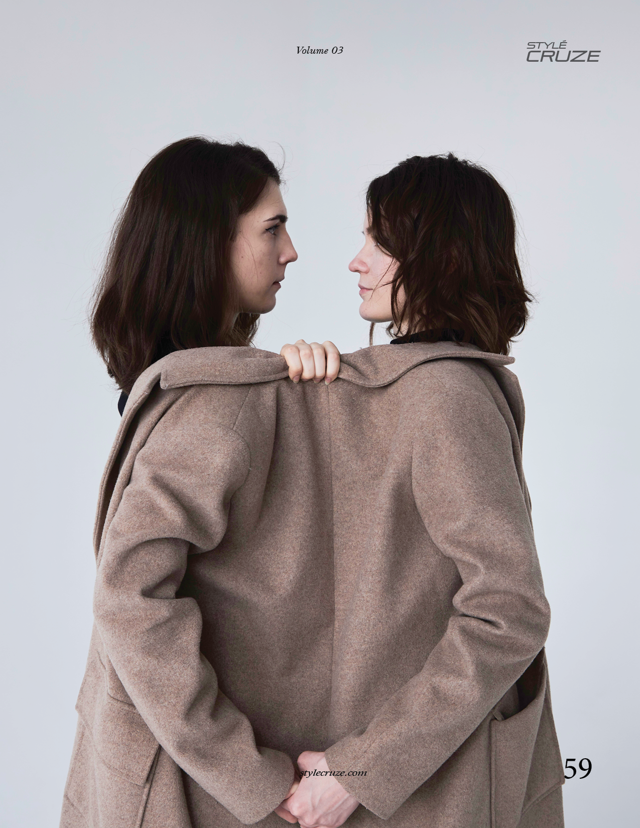 Портрет двух девушек, надевших одно пальто на двоих и смотрящих друг на друга