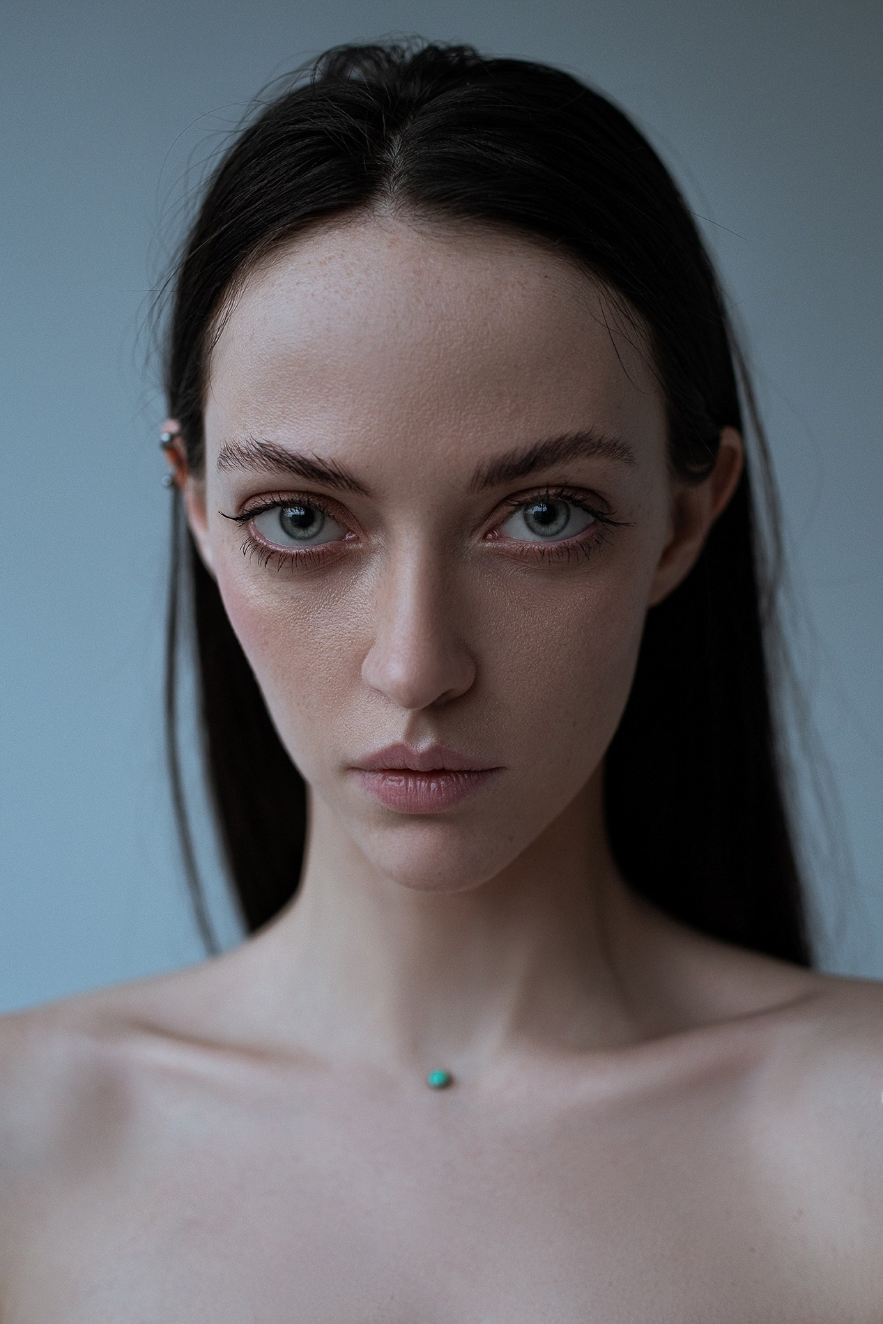 Студийный портрет девушки с веснушками и зелеными глазами
