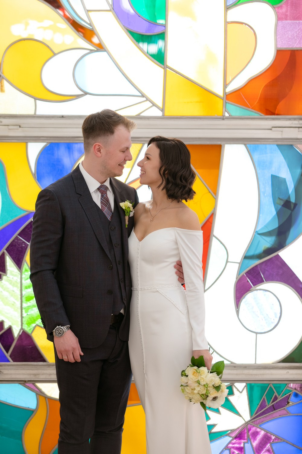 Влюблённая пара на фоне витража в ЗАГСе