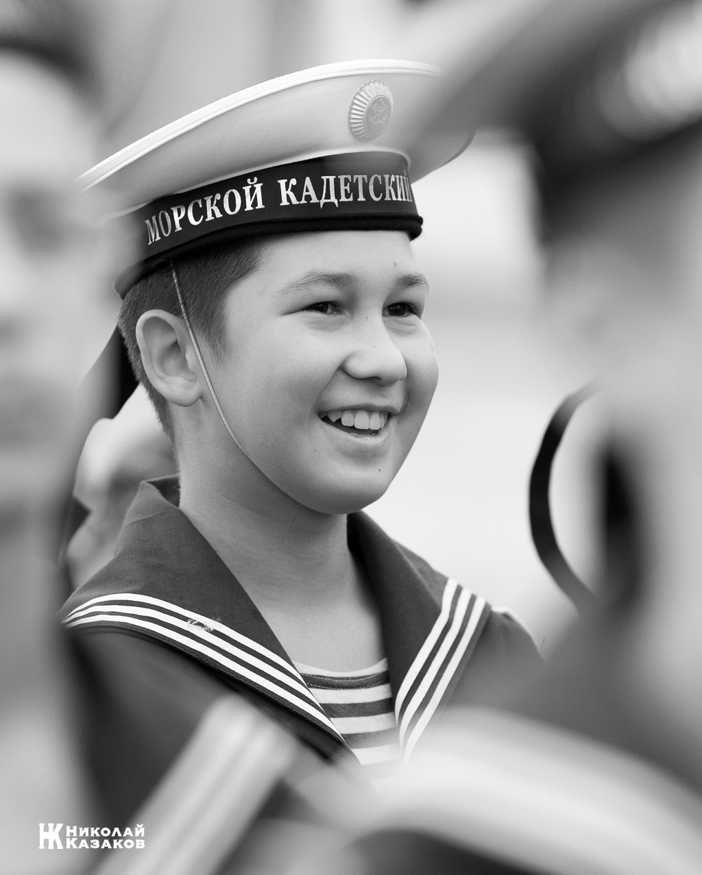 Черно-белый портрет смеющегося воспитанника Кронштадского морского кадетского военного корпуса на построении.