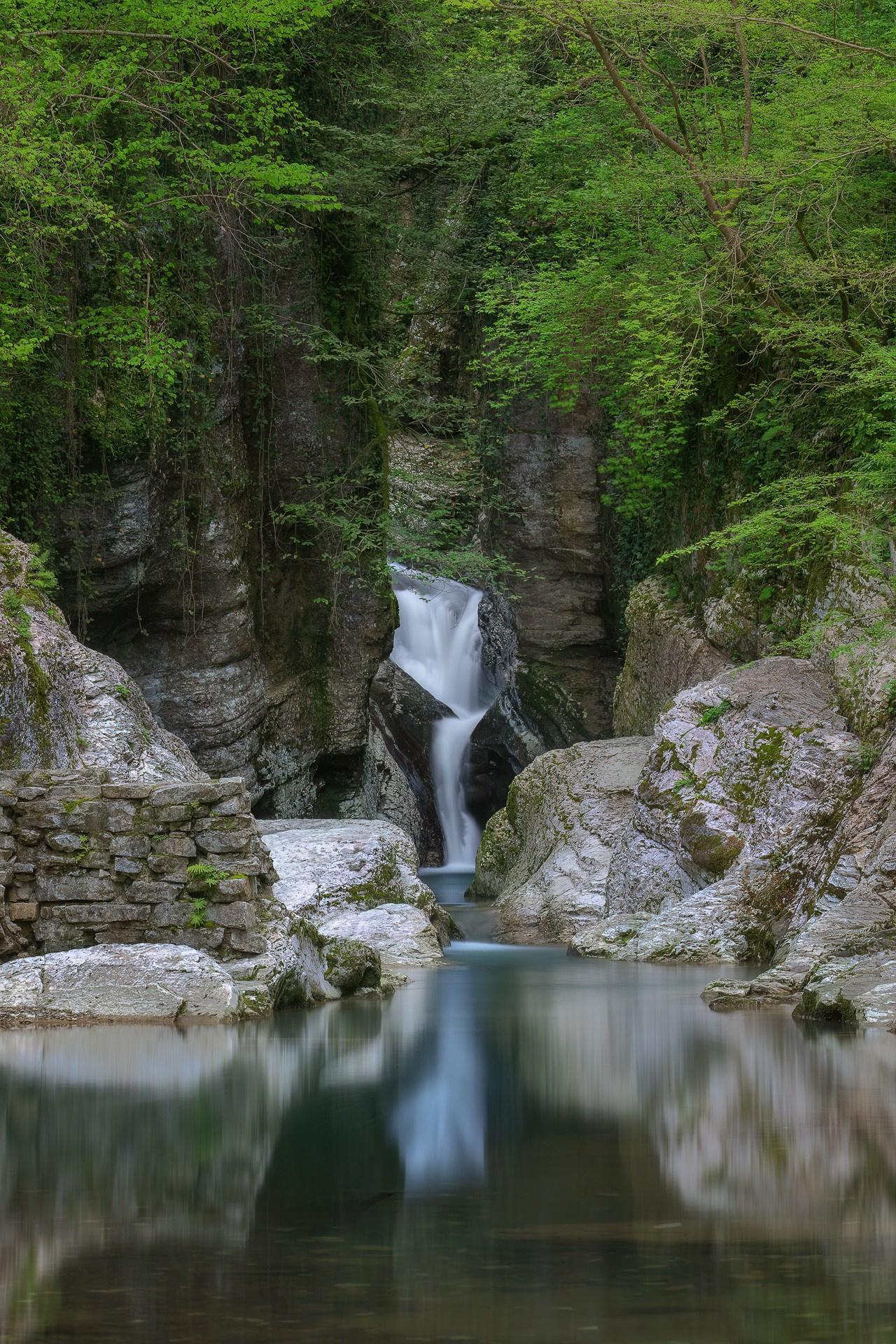 Водопад бежит по скалам заросшим тропическим лесом