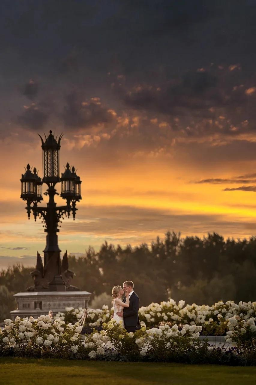 Девушка в свадебном наряде стоит в цветущем саду у замка Гарибальди, отражая атмосферу романтики и роскоши.