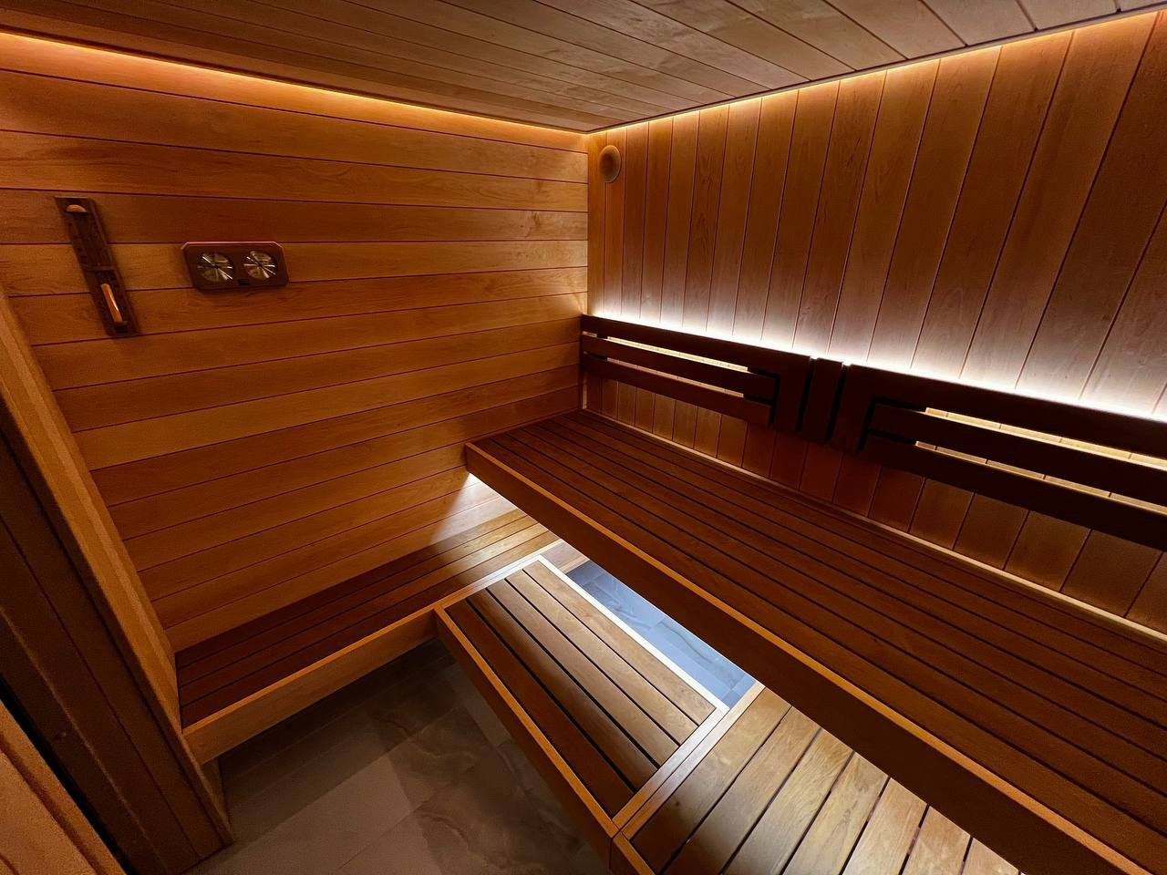 Уютная сауна в КП Новый Мир. В центре внимания- Harvia Cilindro, а закарнизное освещение плавно перетекает в подсветку противопожарного угла. SaunaTopMasters