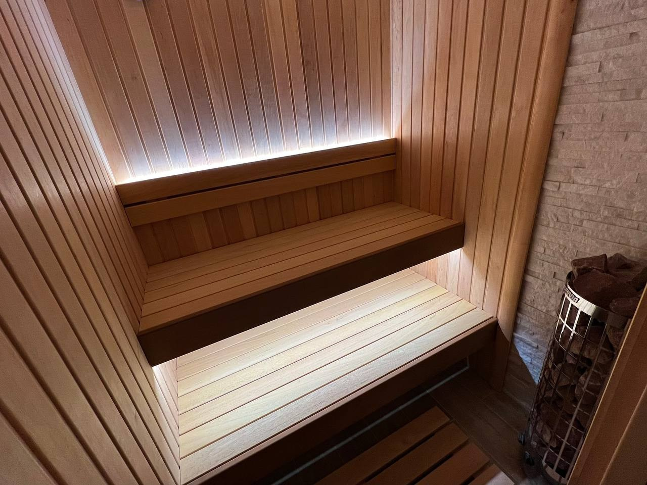 Компактная сауна для двоих на Переправе в отделке из ольхи, абаши и белого кварцита. Жар задаёт Harvia Cilindro. SaunaTopMasters