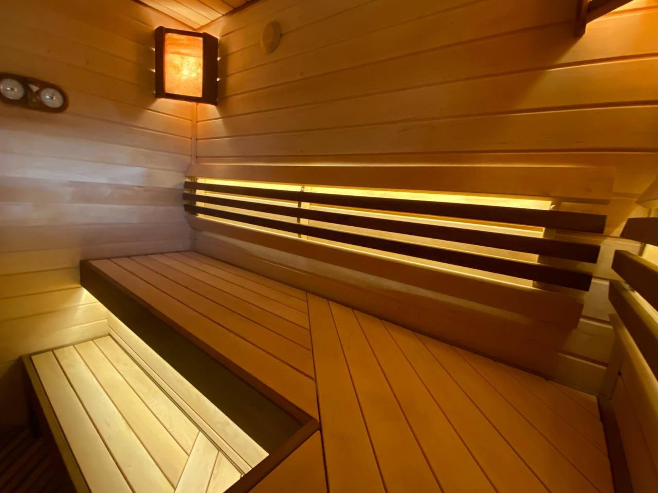 Парная в Токсово: печь Easysteam, ольховые полки с диагональными зашивками, анатомические спинки и мягкий свет солевых ламп. SaunaTopMasters