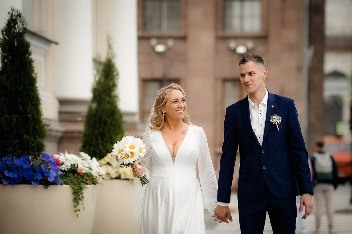 Жених и невеста прогуливаются возле заксобрания в Санкт-Петербурге. Горизонтальный поясной кадр.