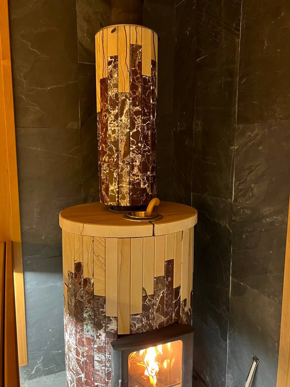 Уютная парная в Колтушах: внутренняя топка, печь в редкой облицовке, термоольха и тёплая линейная подсветка. SaunaTopMasters