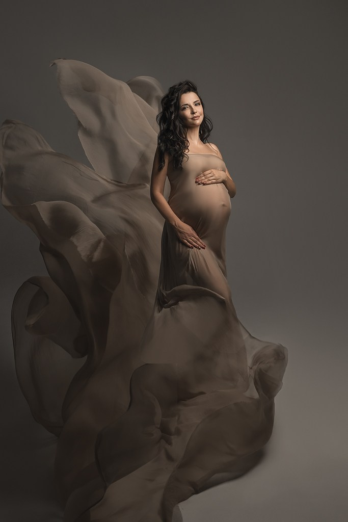 фотосессия беременной в фотостудии на темном фоне в красивом разлетающемся платье, фотография беременности, фотосессия беременных, портрет беременной