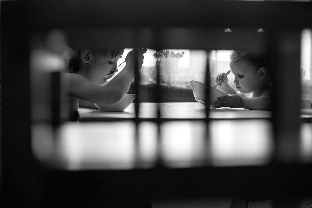 Обед двух сестёр дома. Подглядывание за сёстрами через стульчик. Силуэты двух девочек. У окна.