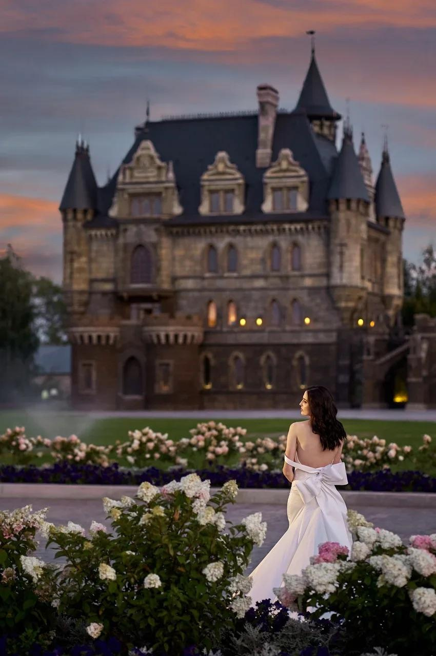 Общий вид замка Гарибальди на закате, где невеста любуется волшебным пейзажем с тёплой подсветкой башен.