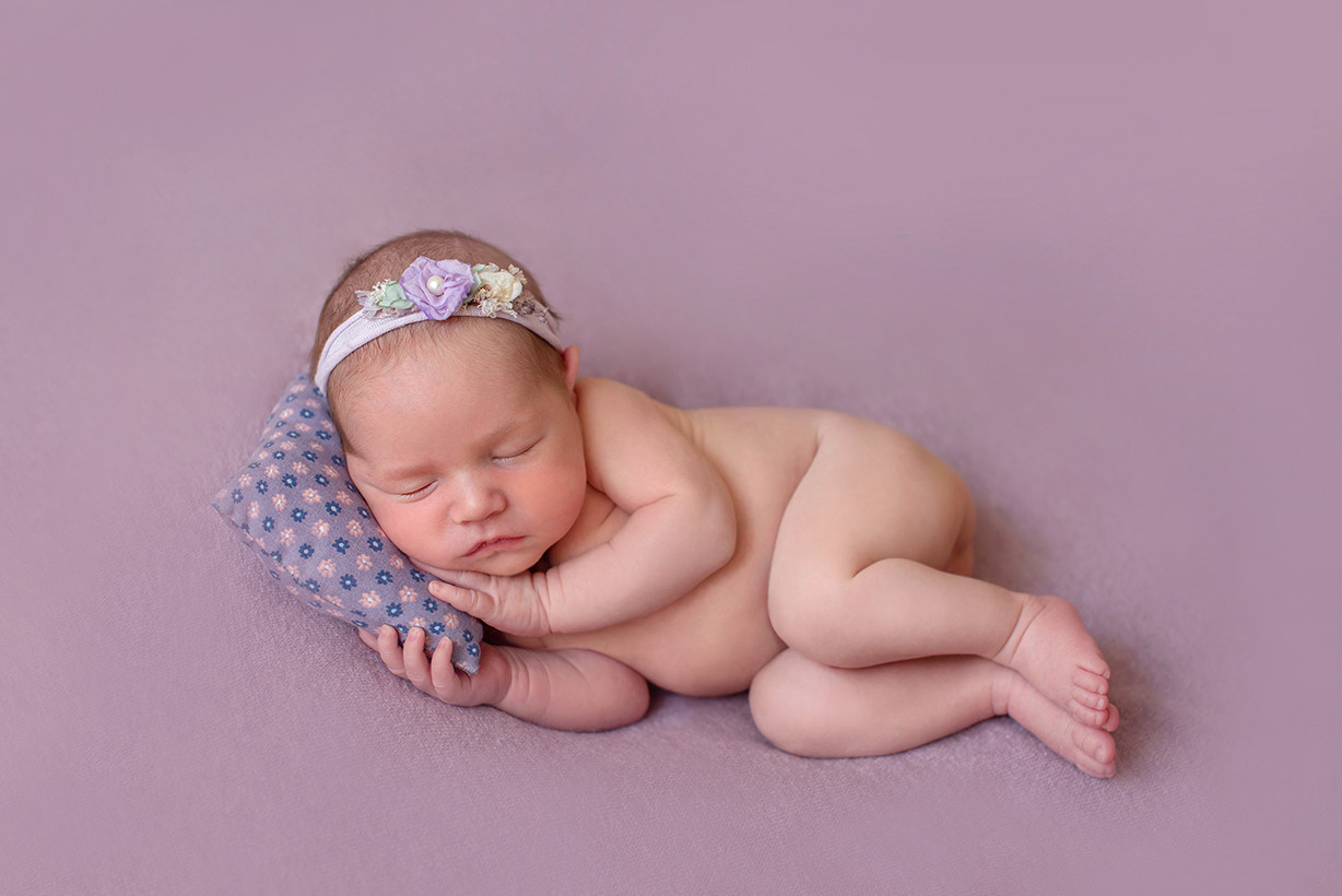 новорожденный лежит в поировке на боку