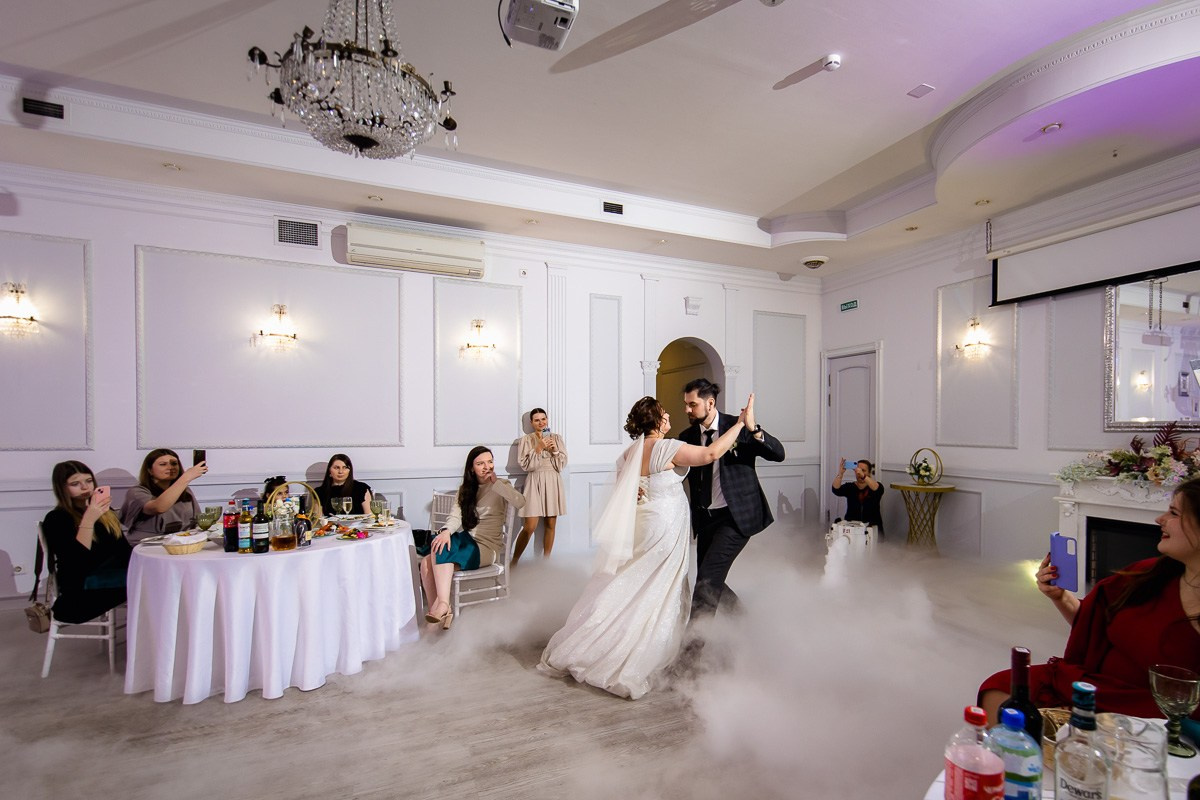 Жених и невеста танцуют первый танец в ресторане Санкт-Петербурга. Горизонтальный кадр. Гости смотрят