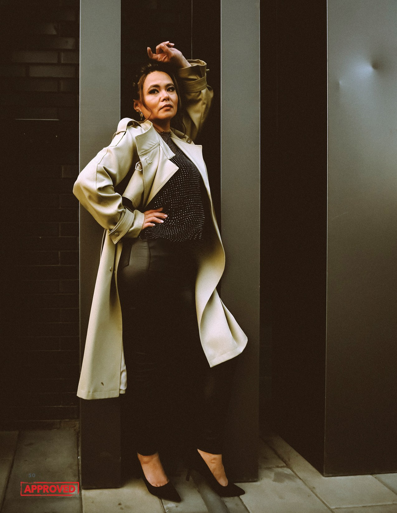 На фото девушка облокотилась о стену дома.