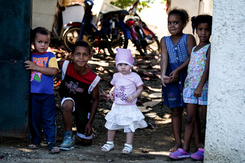 Доминиканская республика, Пуэрто Плато, русская маленькая девочка стоит рядом с чернокожими детьми