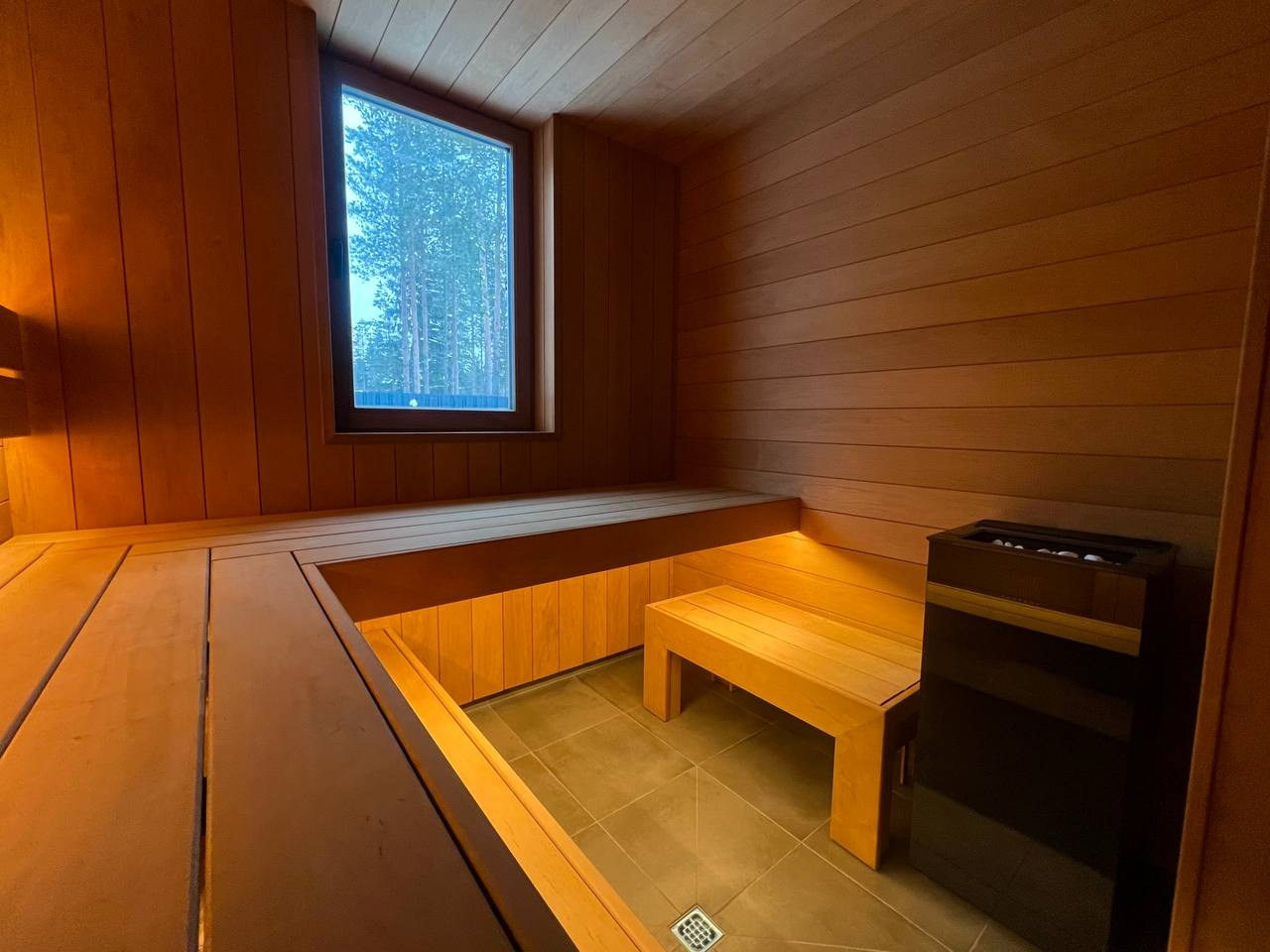 Тёплая парная для коллег из «Печи Горбунова» в Рощино: Sangens в чёрном стекле, широкая термоольха и панорамная входная группа. SaunaTopMasters