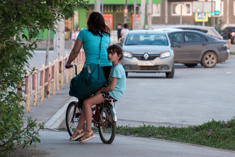 Мама везет дочь на велосипеде