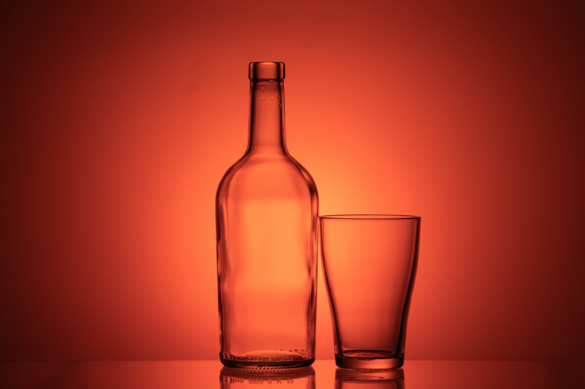 бутылка и стакан на градиентном фоне оранжевом