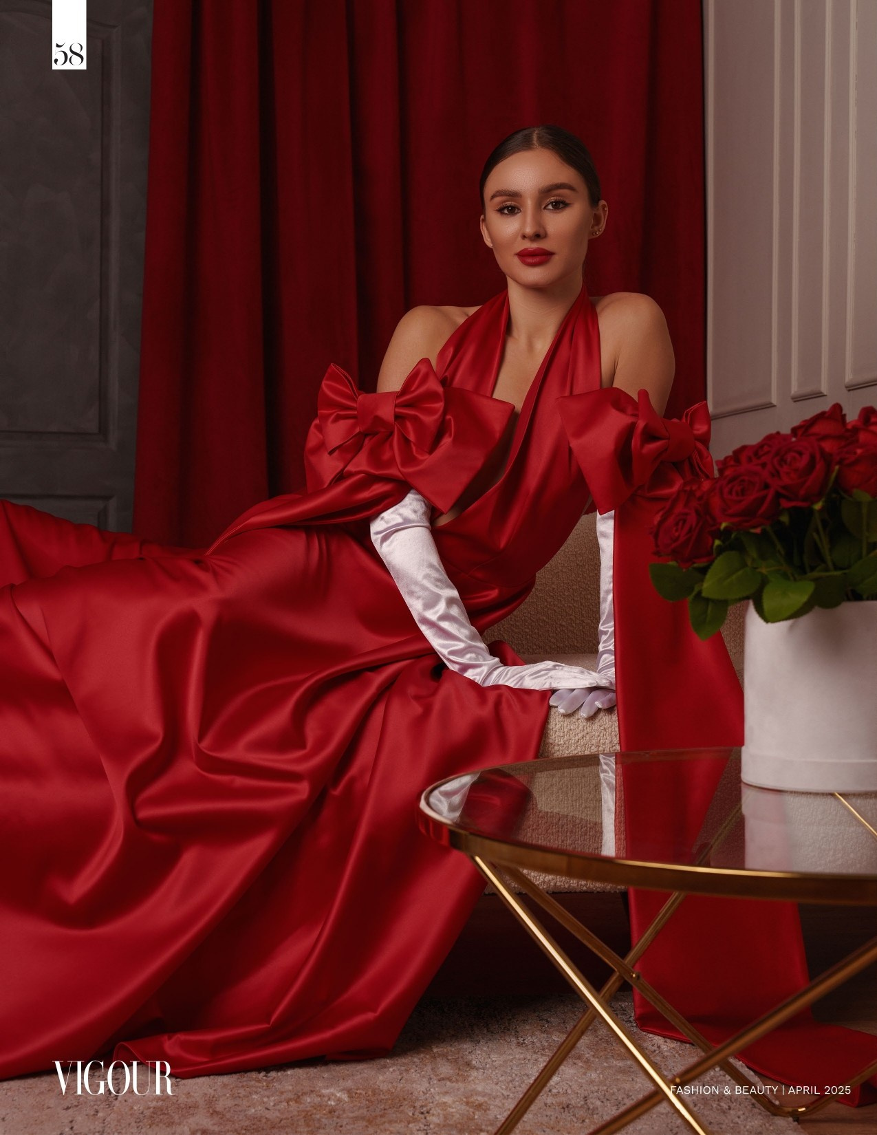 Девушка в роскошном красном праздничном платье сидит на диване в профессиональной фотостудии. Студийный свет мягко подчеркивает складки ткани и элегантный силуэт. Глянцевая ретушь, атмосфера гламура и высокой моды. Идеально для рекламы вечерних платьев, fashion-портфолио или брендовой съемки.