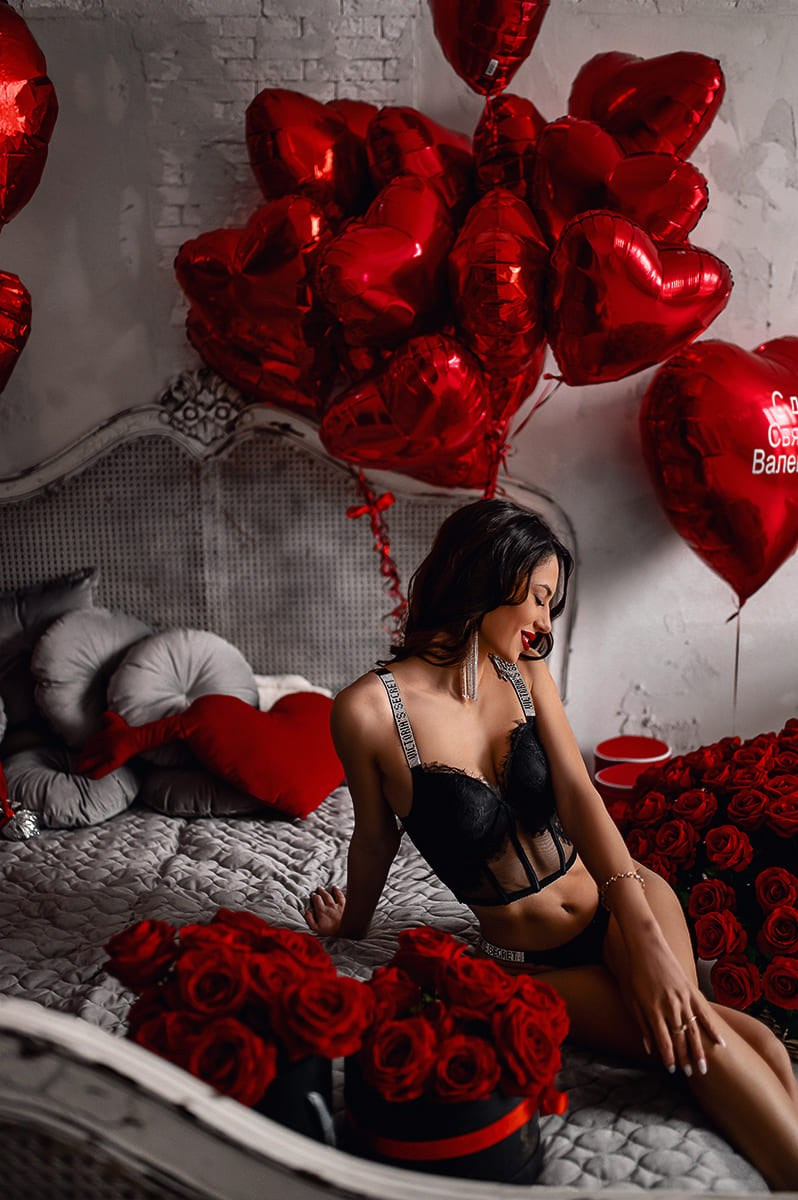 Девушка в белье на кровати с розами и шарами