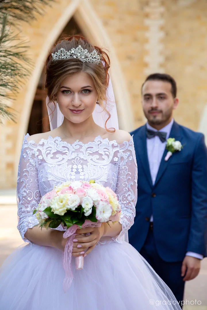 Невеста с букетом и жених сзади нее