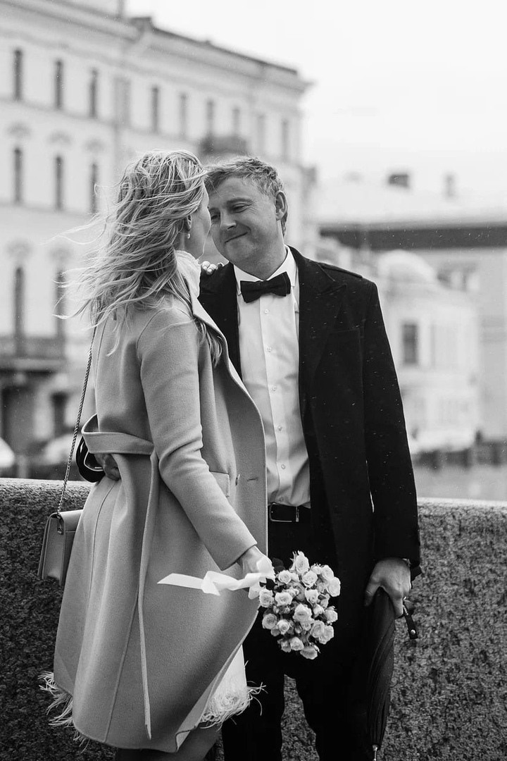 жених и невеста на мосту в санкт-петербурге в ветренную дождьливую погоду  