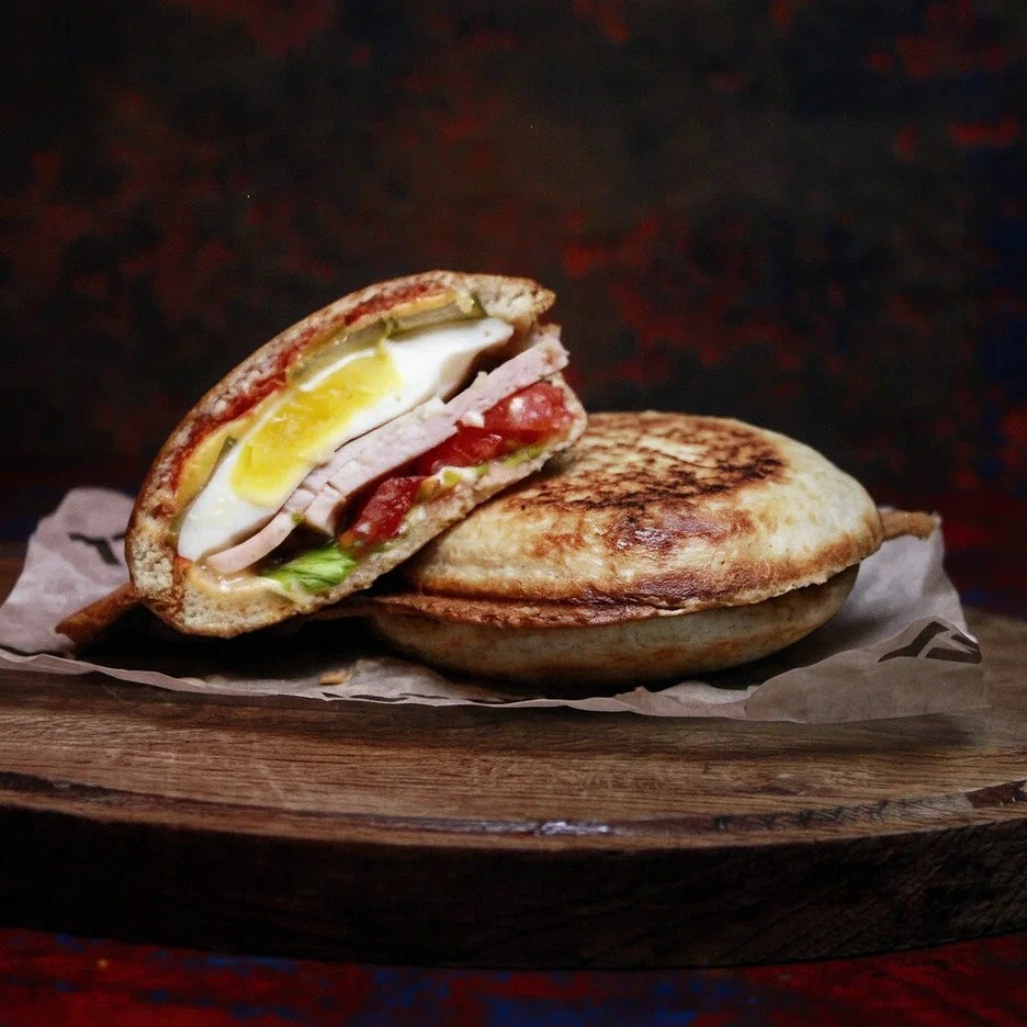 аппетитный бургер с сочными слоями на тёмном фоне