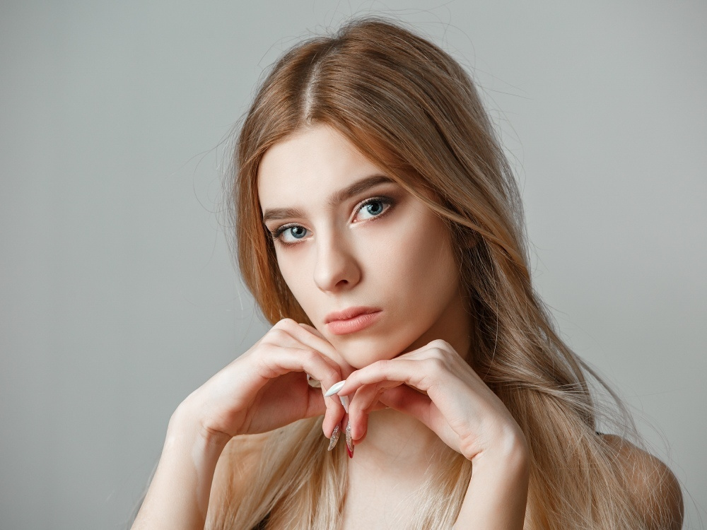 крупный женский портрет в студии на белом фоне, лицо, руки, эмоции, съемка в студии на фонах, рекламное фото