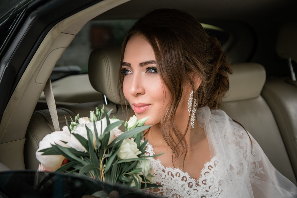 Невеста в автомобиле, смотрит из окна машины