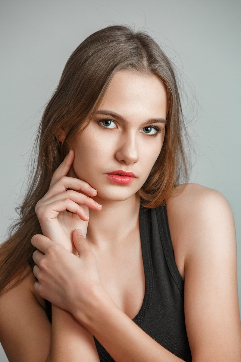 крупный портрет девушки в студии на белом или сером фоне, ретушь