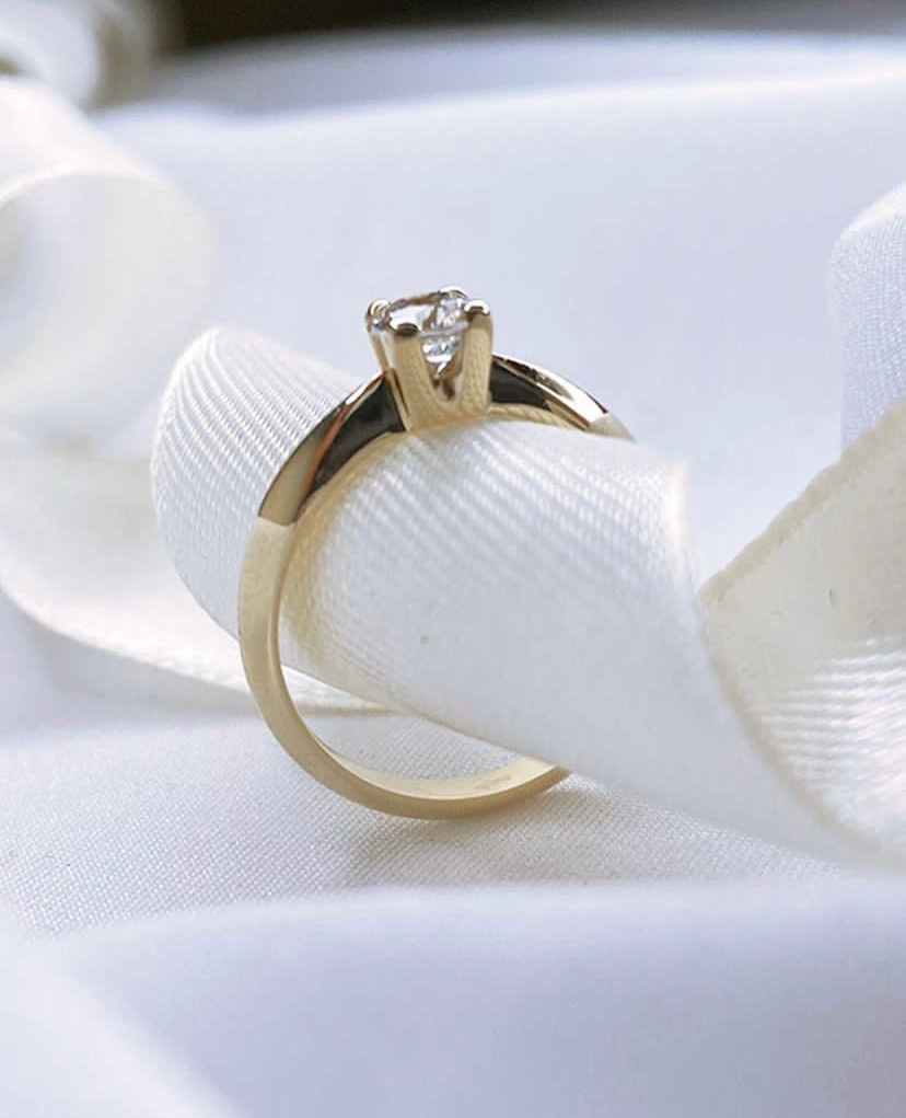 Помолвочное кольцо из желтого золота с камнем муассанит.