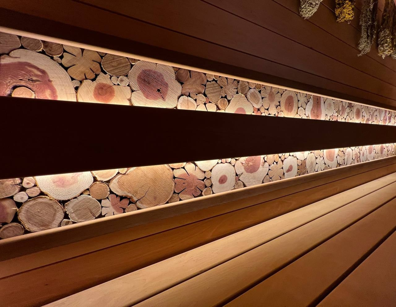 Семейная баня в Рощино из ольхи с можжевеловым панно, яркой печной зоной, закарнизной подсветкой и печью от производителя Aston. SaunaTopMasters