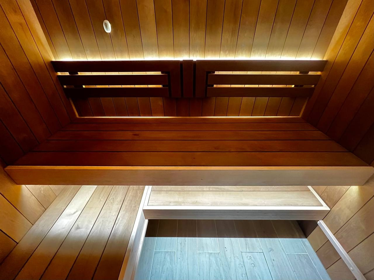 Сауна в Рощино на базе электрокаменки с парогенератором Harvia Virta выполнена из термоольхи с интеграцией световых линий из можжевельника. SaunaTopMasters