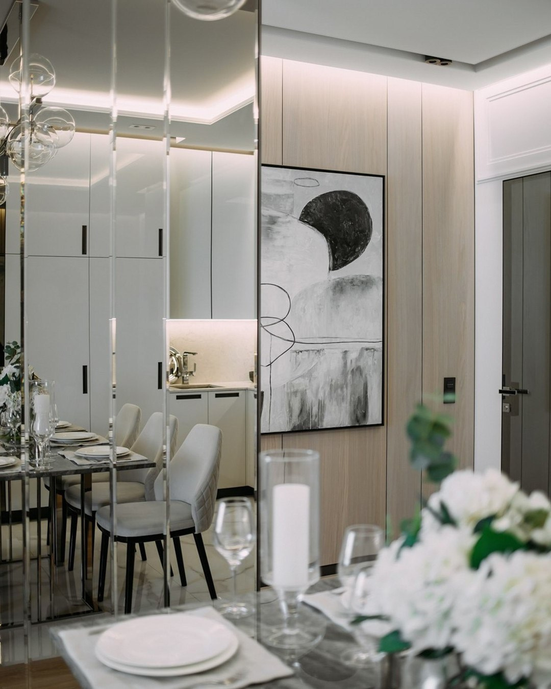 Зона столовой с зеркальной панелью и современной абстрактной картиной | Валерия Котович