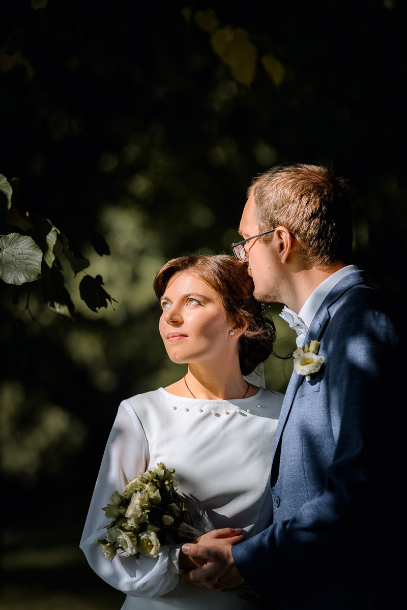 Жених и невеста смотрят в сторону на аллее парка ЗАГСа Красносельского района СПб, поясной план.